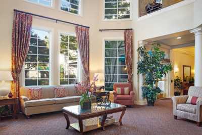 A spacious living room with large windows, elegant furniture, and decorative elements.