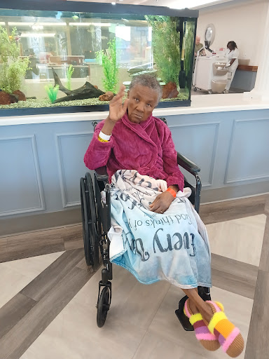A cheerful child in a wheelchair giving a peace sign, showcasing resilience and positivity.