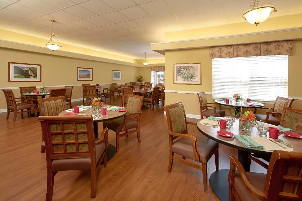 Cozy dining area with neatly arranged tables and chairs, featuring warm decor.