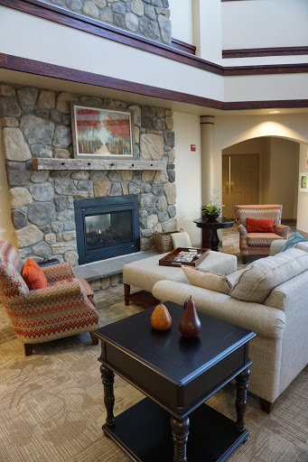 A cozy living room featuring a stone fireplace, comfortable seating, and stylish decor.