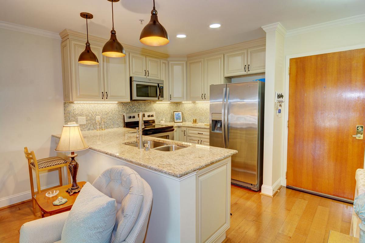 A modern kitchen with stainless steel appliances and elegant lighting.