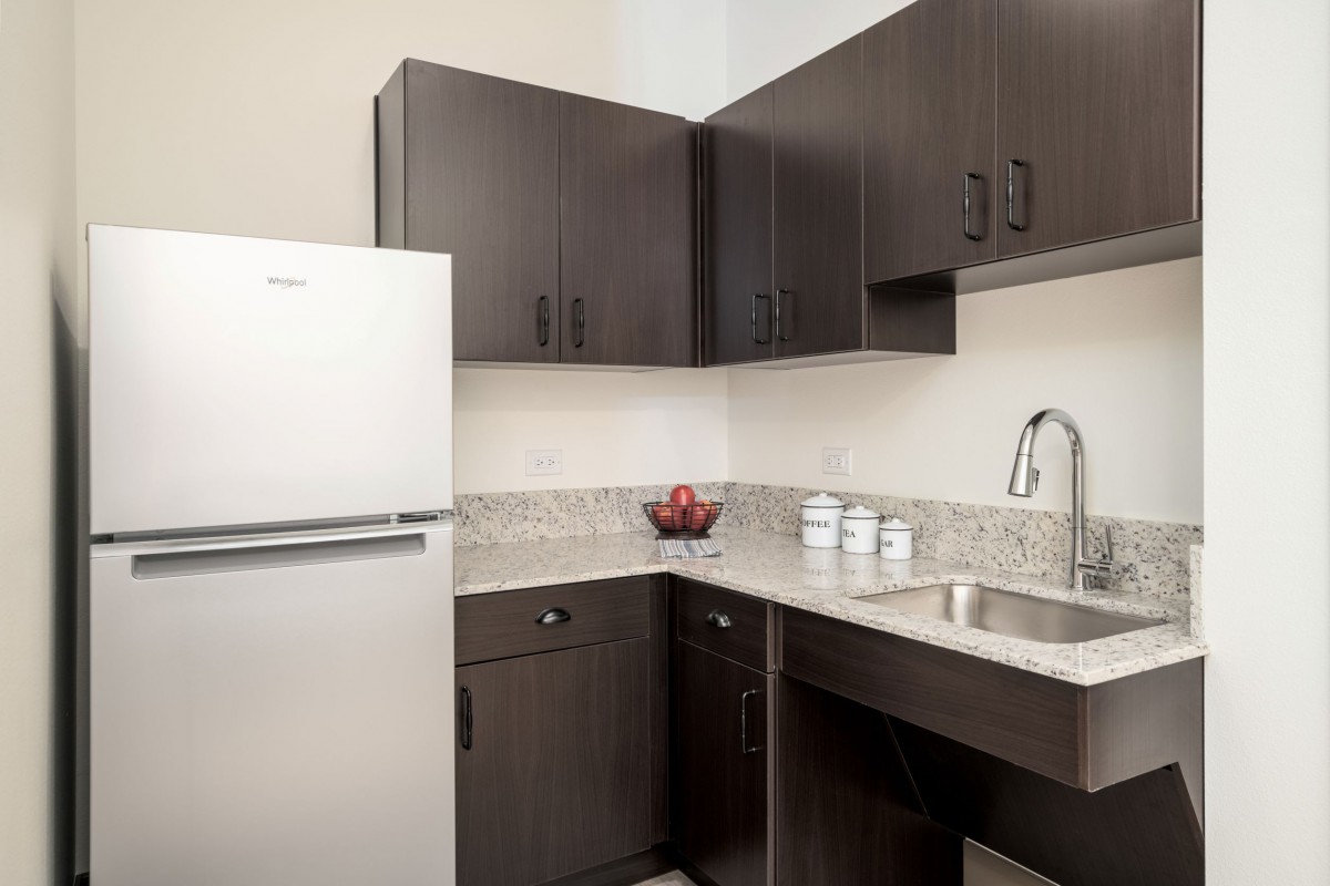 A modern kitchen with dark cabinets and a sleek countertop.