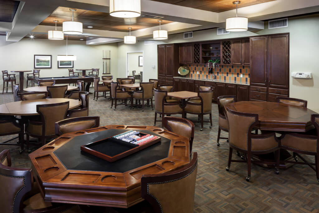 A spacious and well-furnished lounge area with tables and chairs arranged neatly under modern lighting.