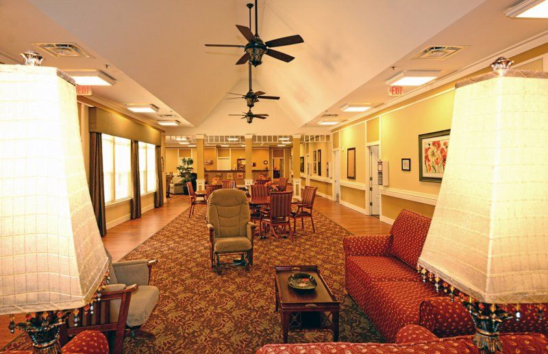 A spacious living area with comfortable seating, ceiling fans, and warm lighting.