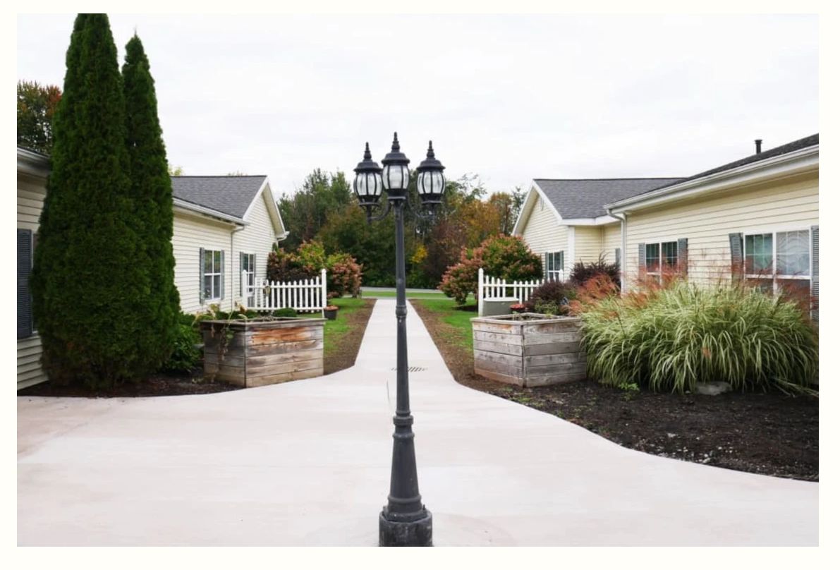 A symmetrical view of a pathway flanked by two buildings and centered with a classic lamp post.