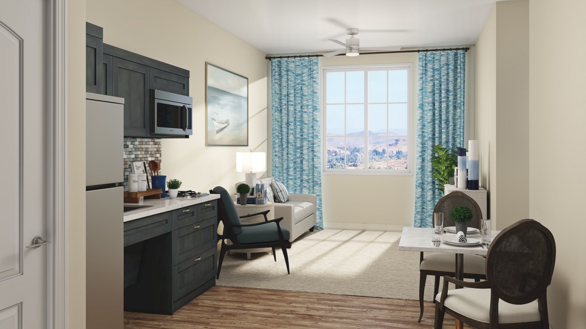 A modern living space with a kitchen, comfortable seating, and large windows with blue curtains.