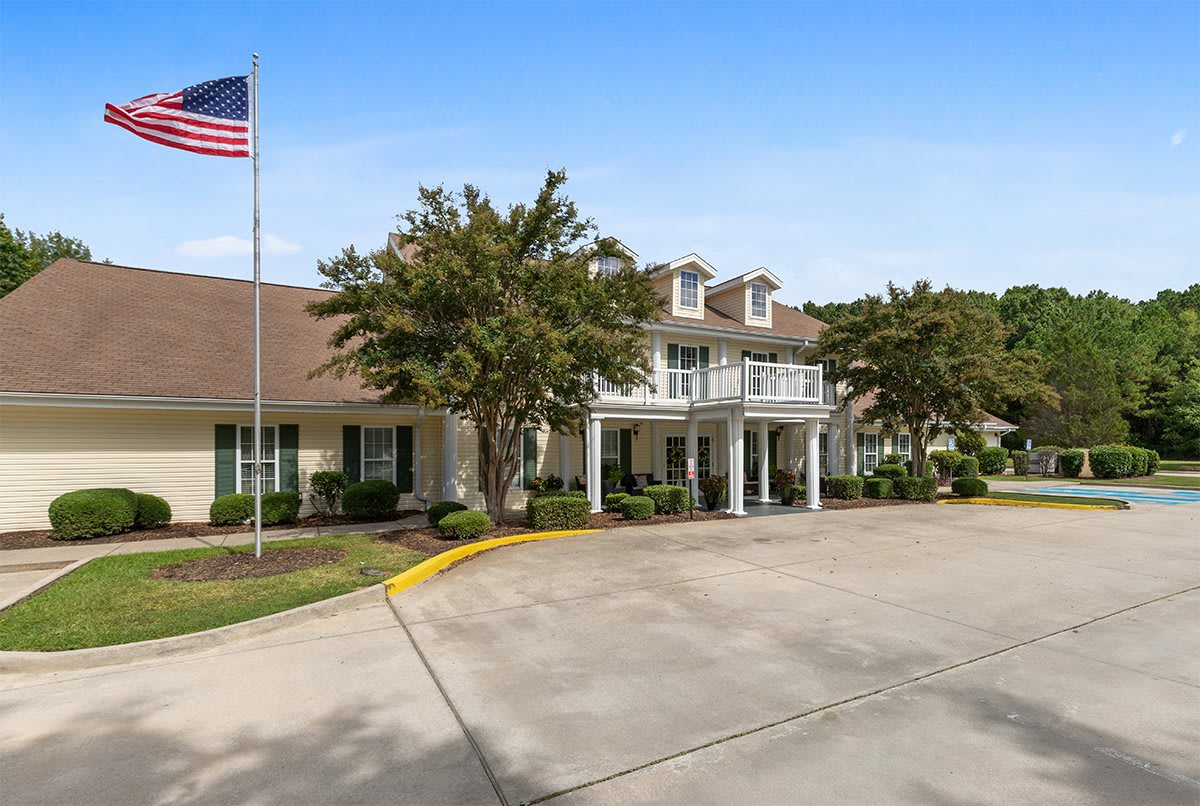A large building with a driveway and an American flag.