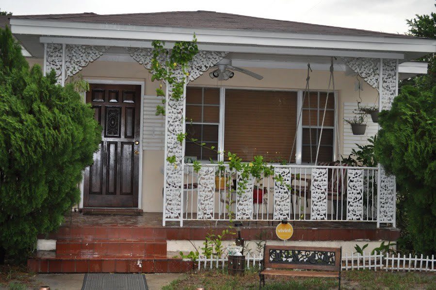 A cozy porch with vines growing on the railing and a swing, adding charm to the house's entrance.