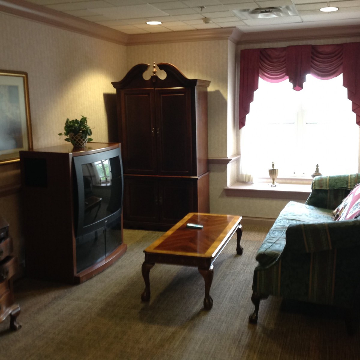 A cozy living room with a sofa, coffee table, and entertainment center.