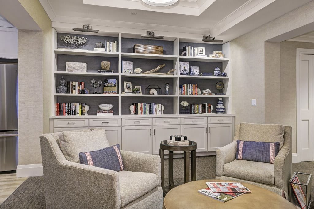 A cozy living room with well-organized bookshelves and comfortable armchairs.