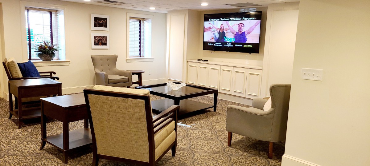 A cozy living room with comfortable seating and a large television on the wall.