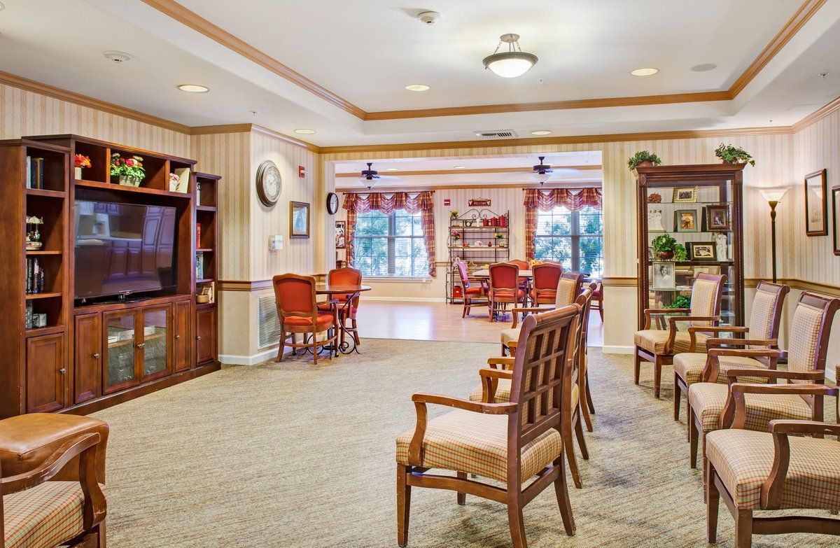 A cozy library room with arranged seating and bookshelves under bright lighting.