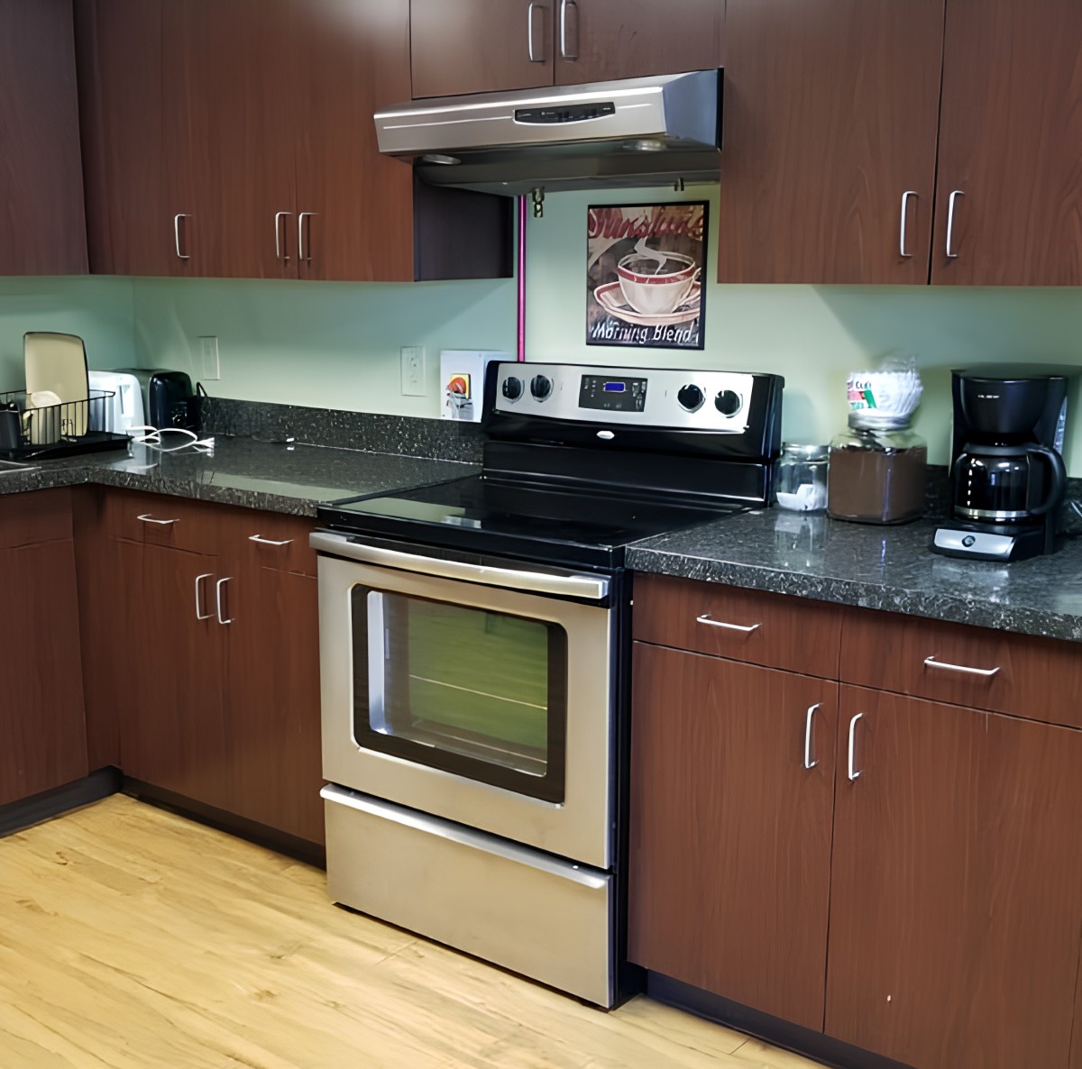 A modern kitchen with stainless steel appliances and wooden cabinets.