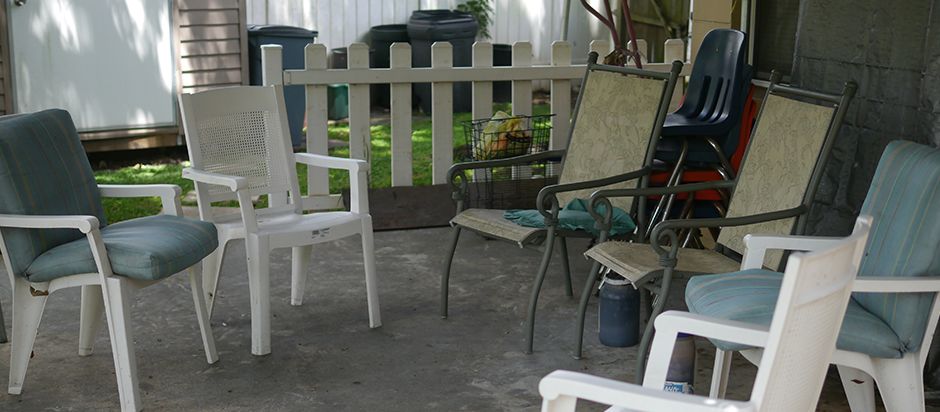 A cozy outdoor patio area with chairs and a view of the backyard garden.