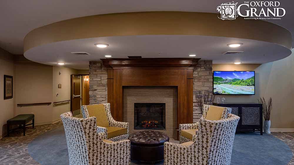 A cozy seating area with armchairs arranged around a fireplace.