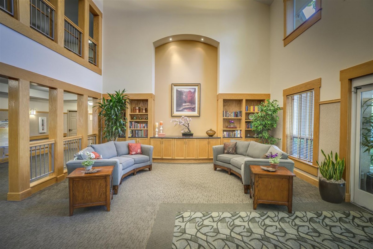 A welcoming lobby area with comfortable seating, decorative plants, and bookshelves.