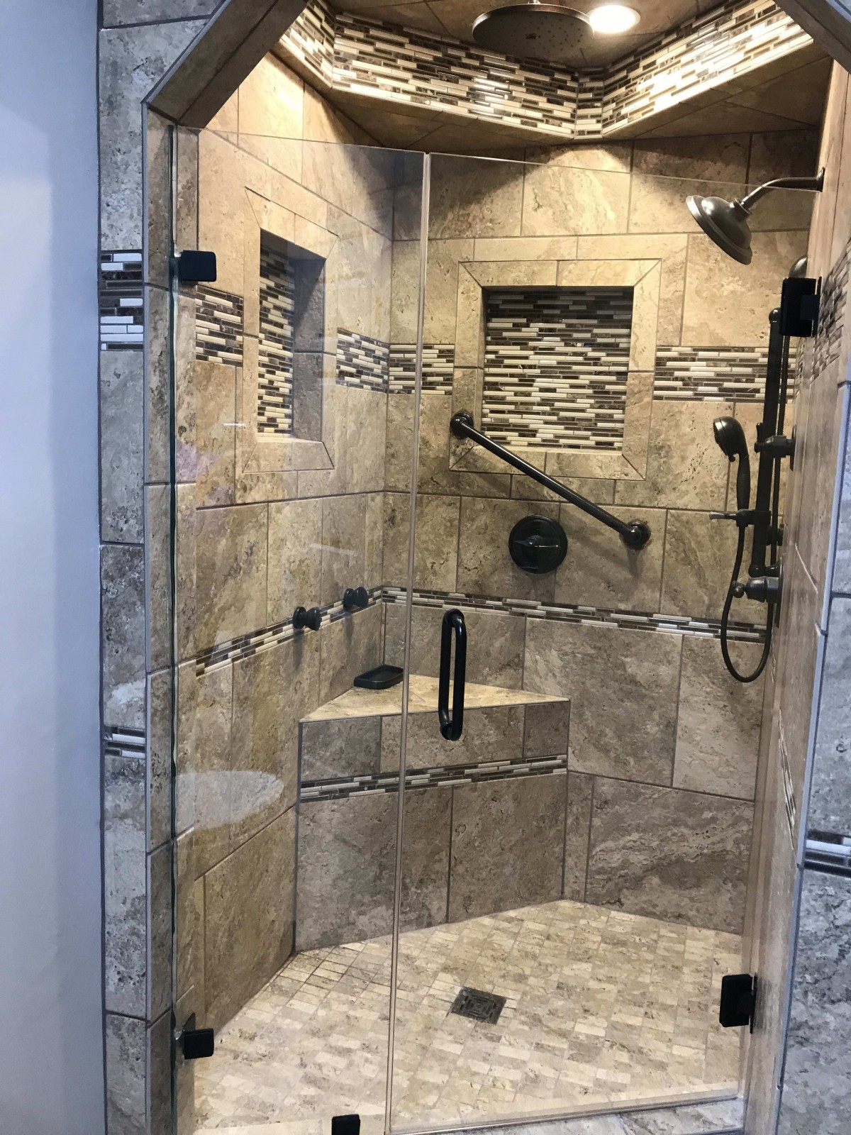 A modern, tiled shower with glass doors and sleek fixtures.