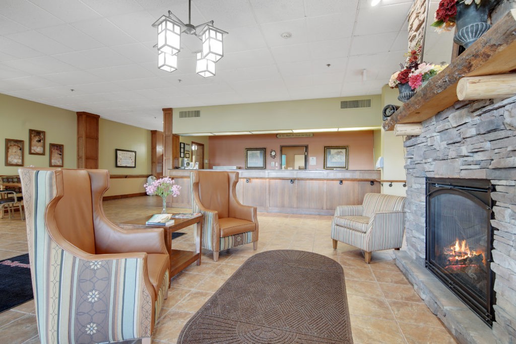 A cozy hotel lobby with seating, a reception desk, and a fireplace.