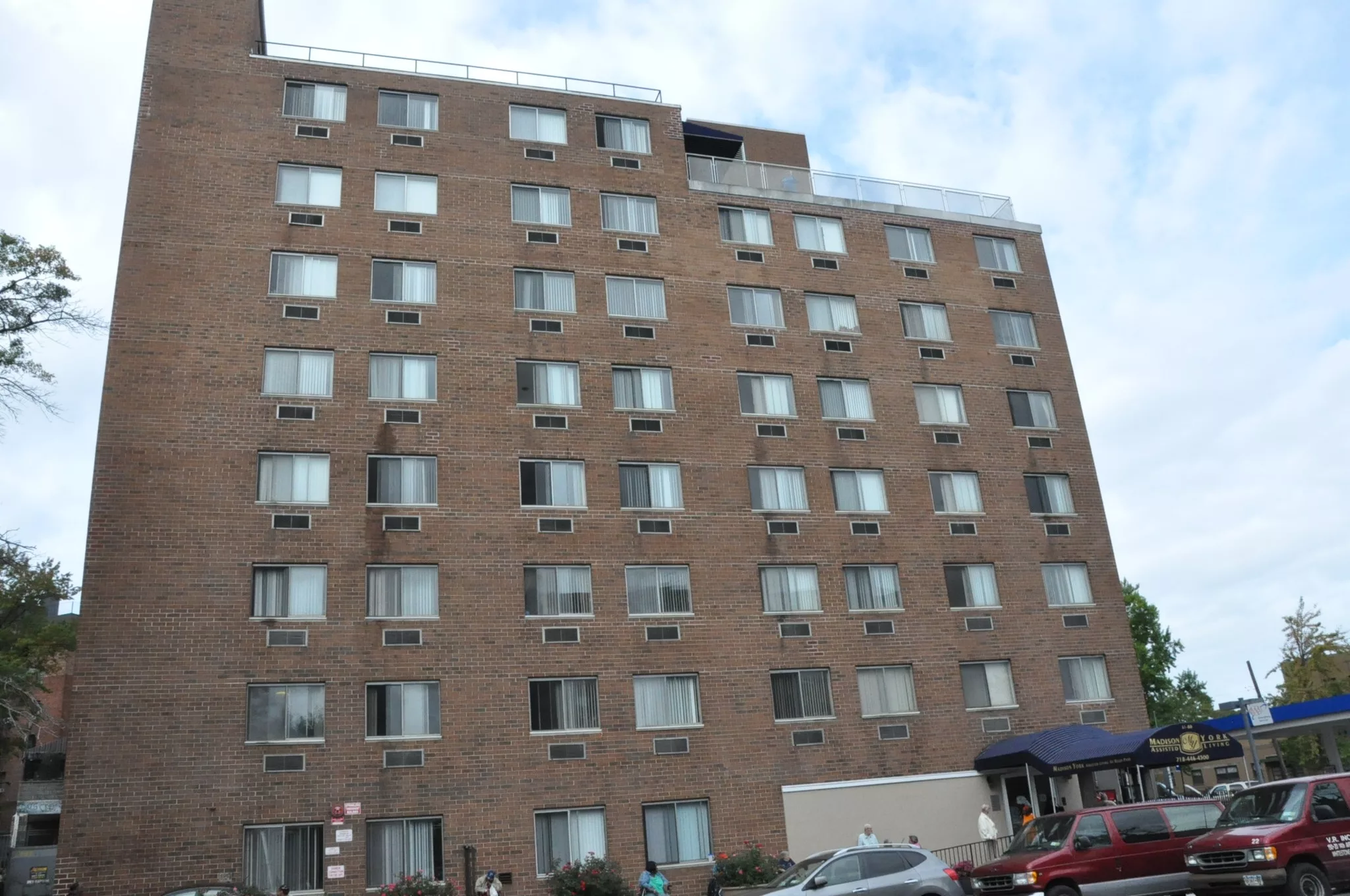 A multi-story brick apartment building with numerous windows in an urban setting.
