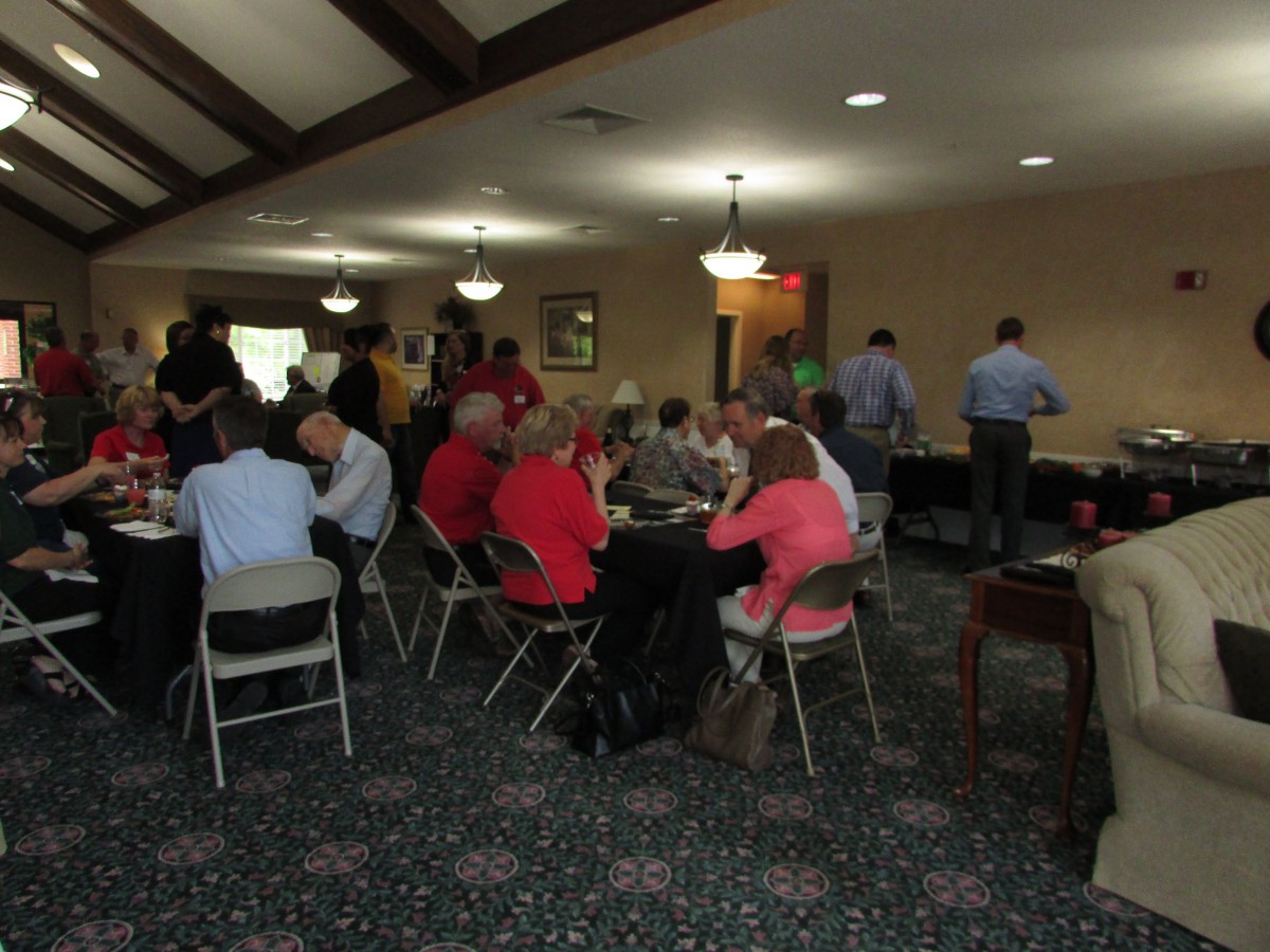 A group of people seated and conversing at an indoor social gathering.