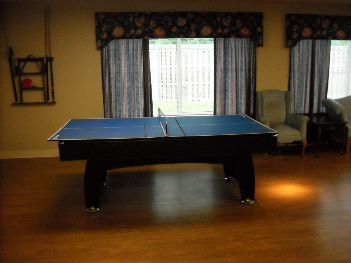 An indoor recreation room with a blue ping pong table.