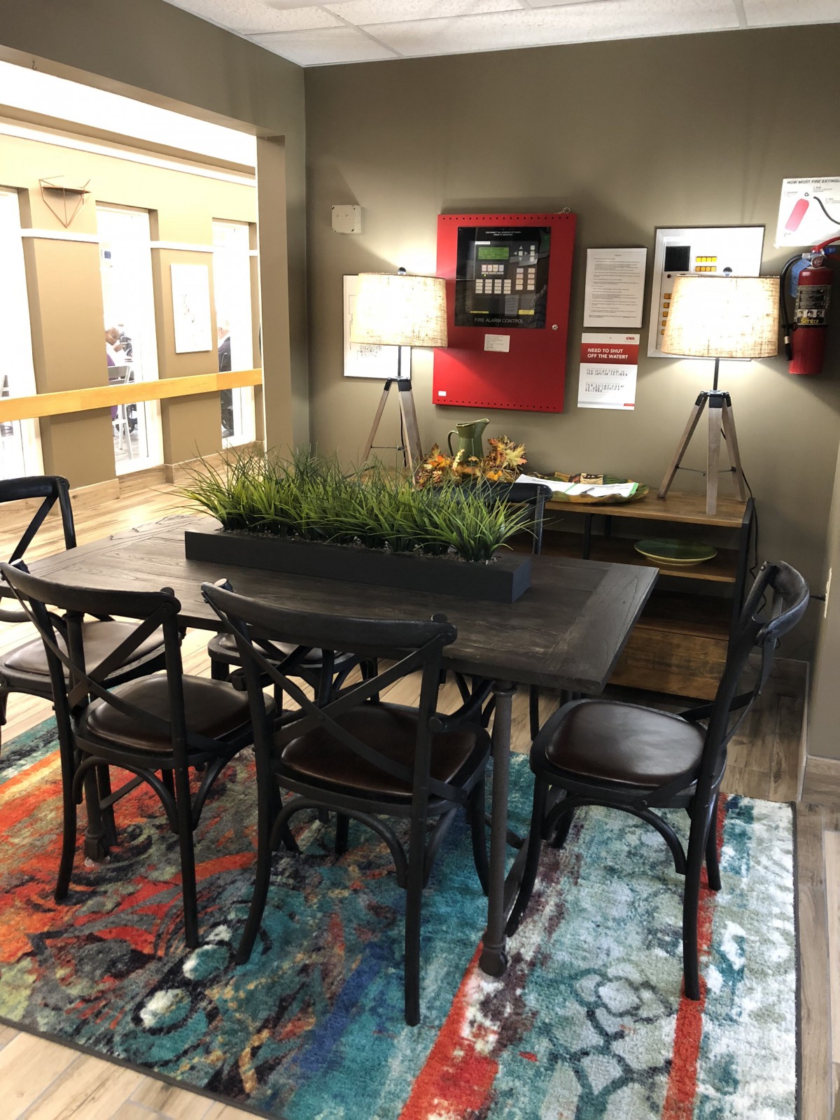 A cozy dining area with a wooden table, chairs, decorative plants, and ambient lighting.