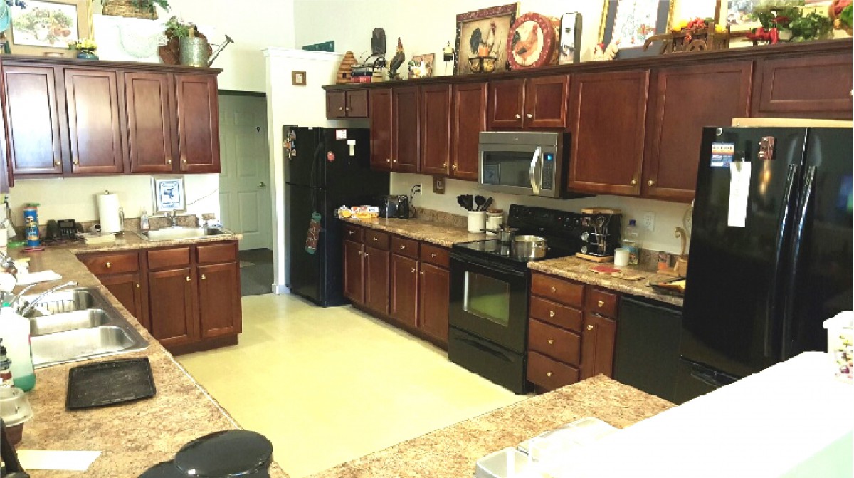 A spacious kitchen featuring dark wood cabinets and modern appliances.