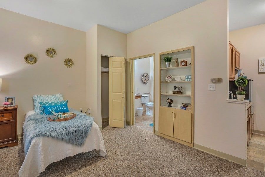 Cozy bedroom with attached bathroom and decorative shelving.