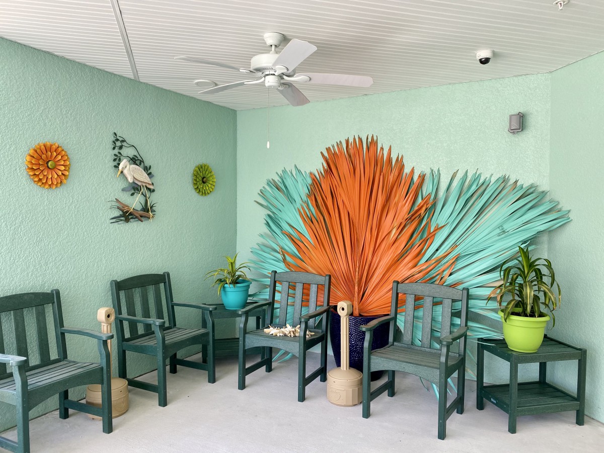 A vibrant waiting room with colorful chairs and a tropical mural.
