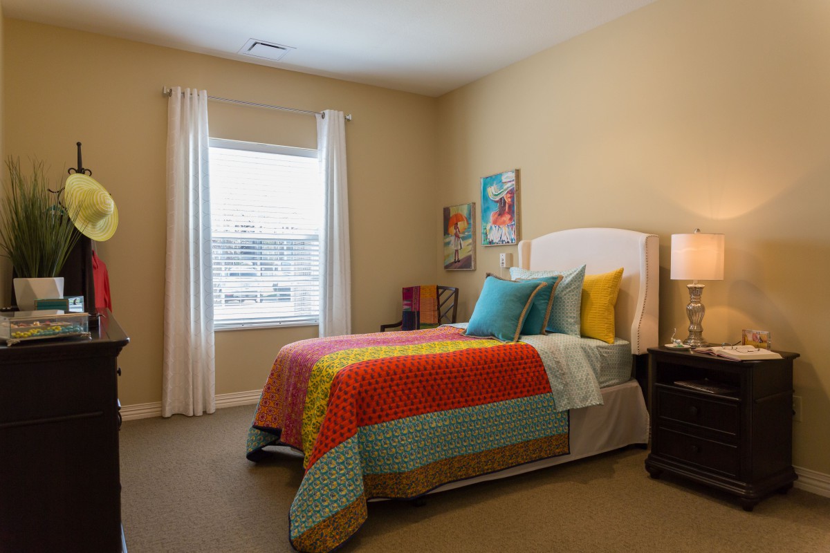 A cozy bedroom featuring colorful bedding and modern decor.