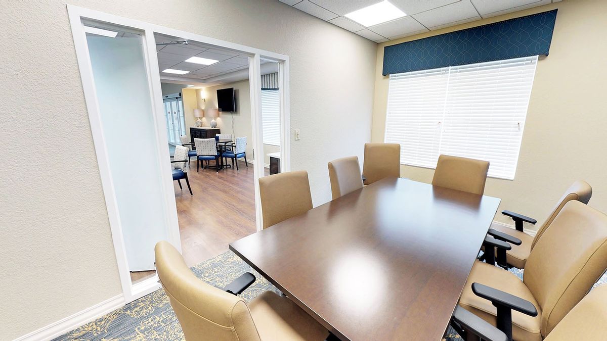 A modern conference room with a large meeting table and comfortable chairs.