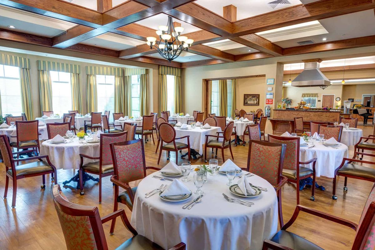 A spacious and elegantly designed dining room with neatly arranged tables and chairs.