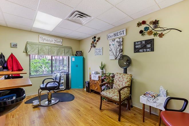 A cozy and well-decorated hair salon interior with chairs and wall decorations.