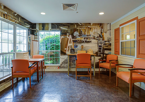A cozy interior space featuring orange furniture and a decorative wall mural.