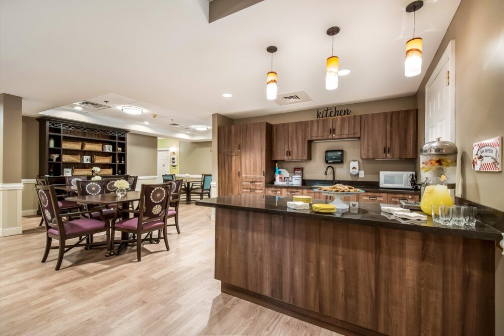 A modern kitchen and dining area with wooden cabinets and stylish lighting.
