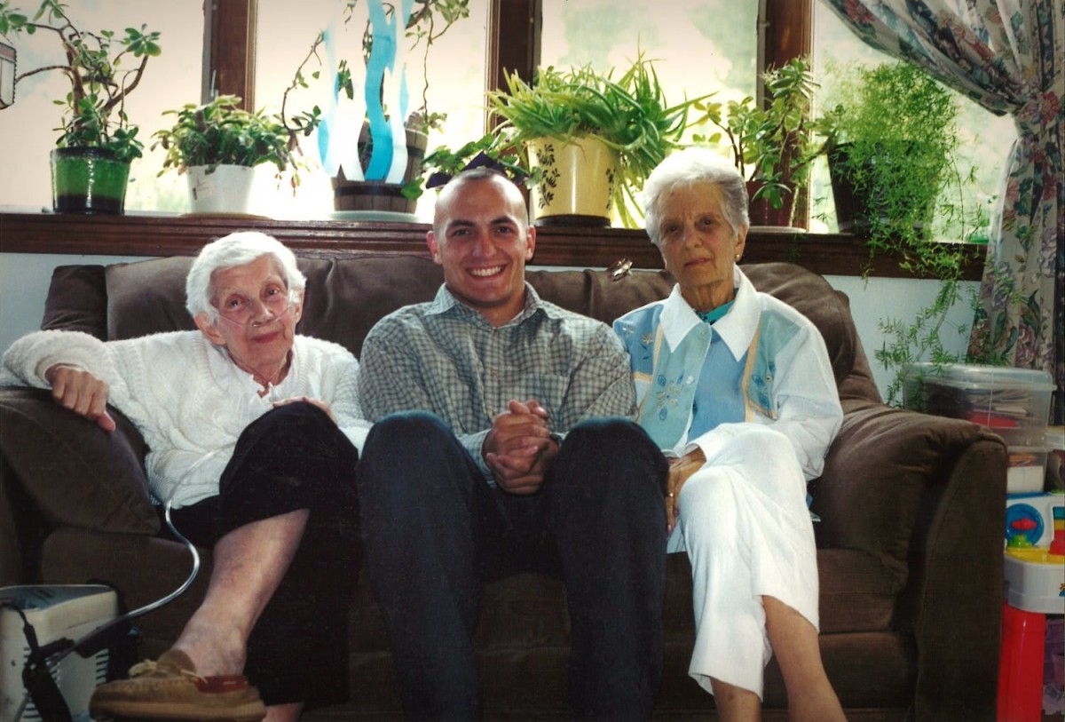 A group of three people sitting together on a couch in a cozy living room.
