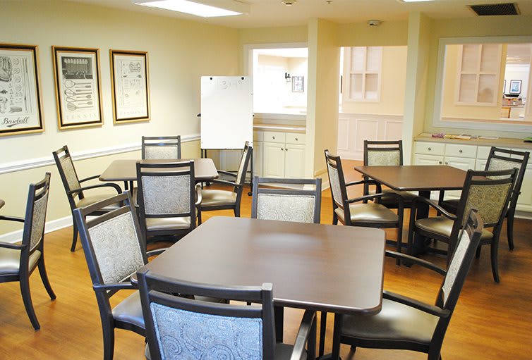 A well-lit dining room with multiple tables and chairs arranged neatly.