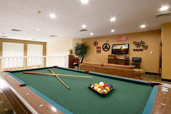 A cozy game room featuring a pool table and comfortable seating area.
