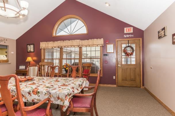 A cozy dining room with a floral tablecloth and wooden furniture.