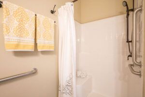 A clean bathroom with a shower area and decorative towels.