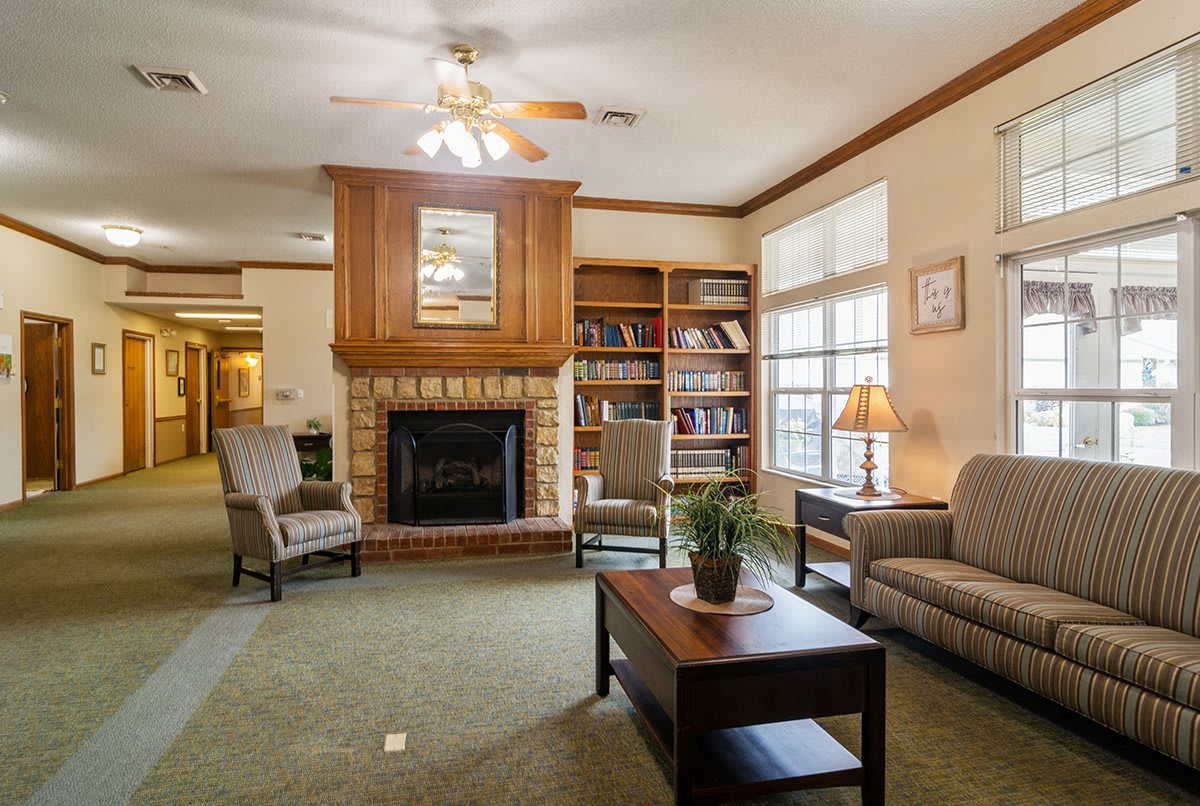 A cozy living room with a fireplace, bookshelves, and comfortable seating.