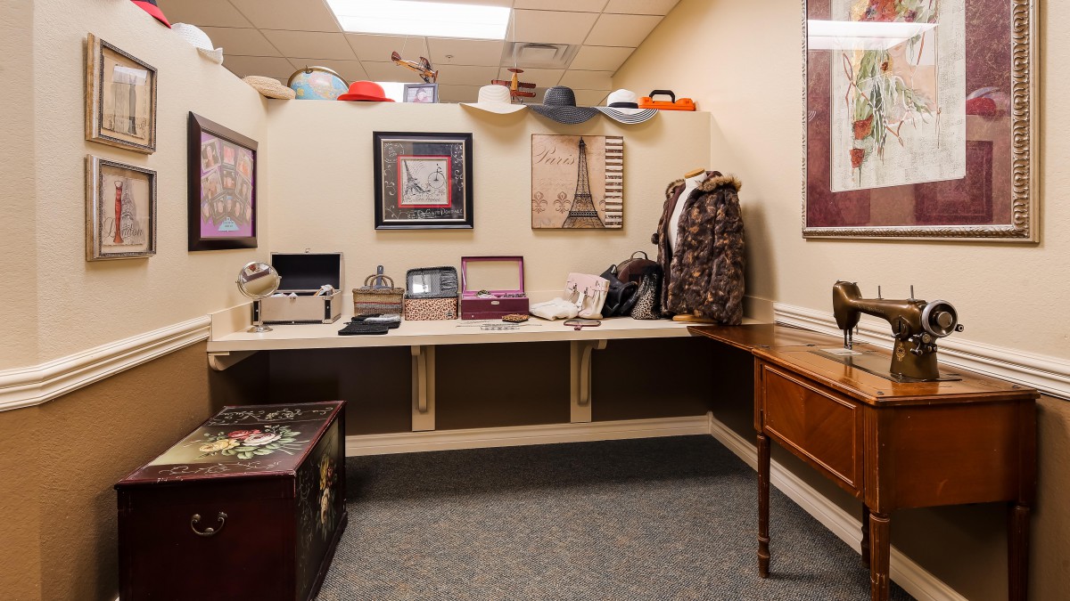 A room with hats and coats displayed, featuring furniture and decorative paintings.