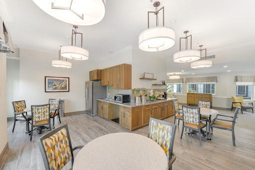A modern kitchen and dining area featuring stylish light fixtures and comfortable seating.