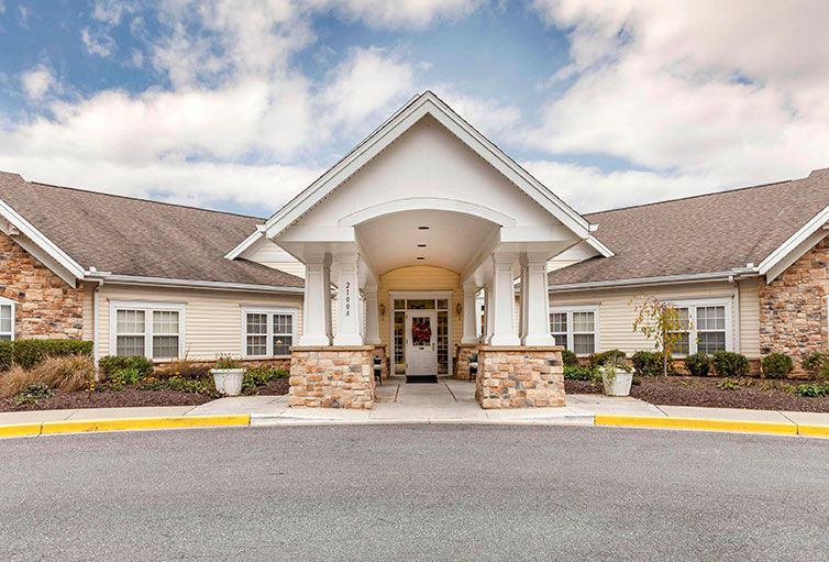 Front entrance of a residential building with columns and a stone facade.