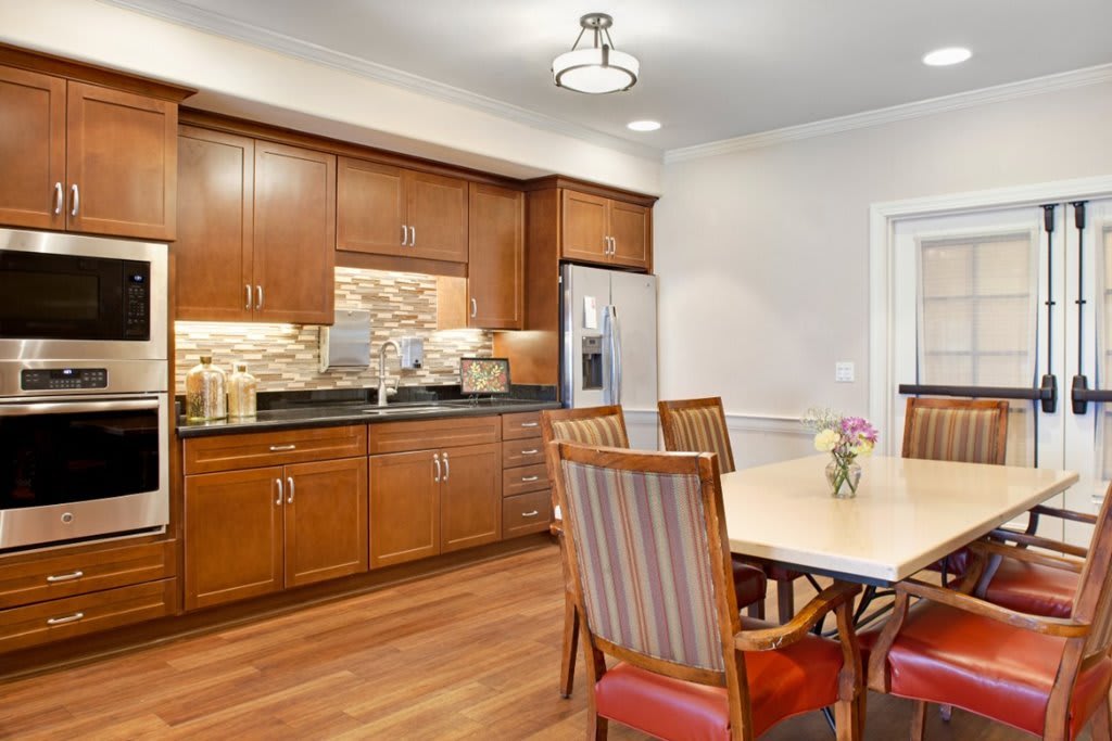 A modern kitchen and dining area with wooden cabinets and a hardwood floor.