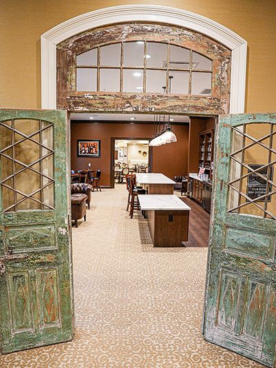 A warm and inviting interior featuring rustic doors opening into a cozy kitchen and dining area.