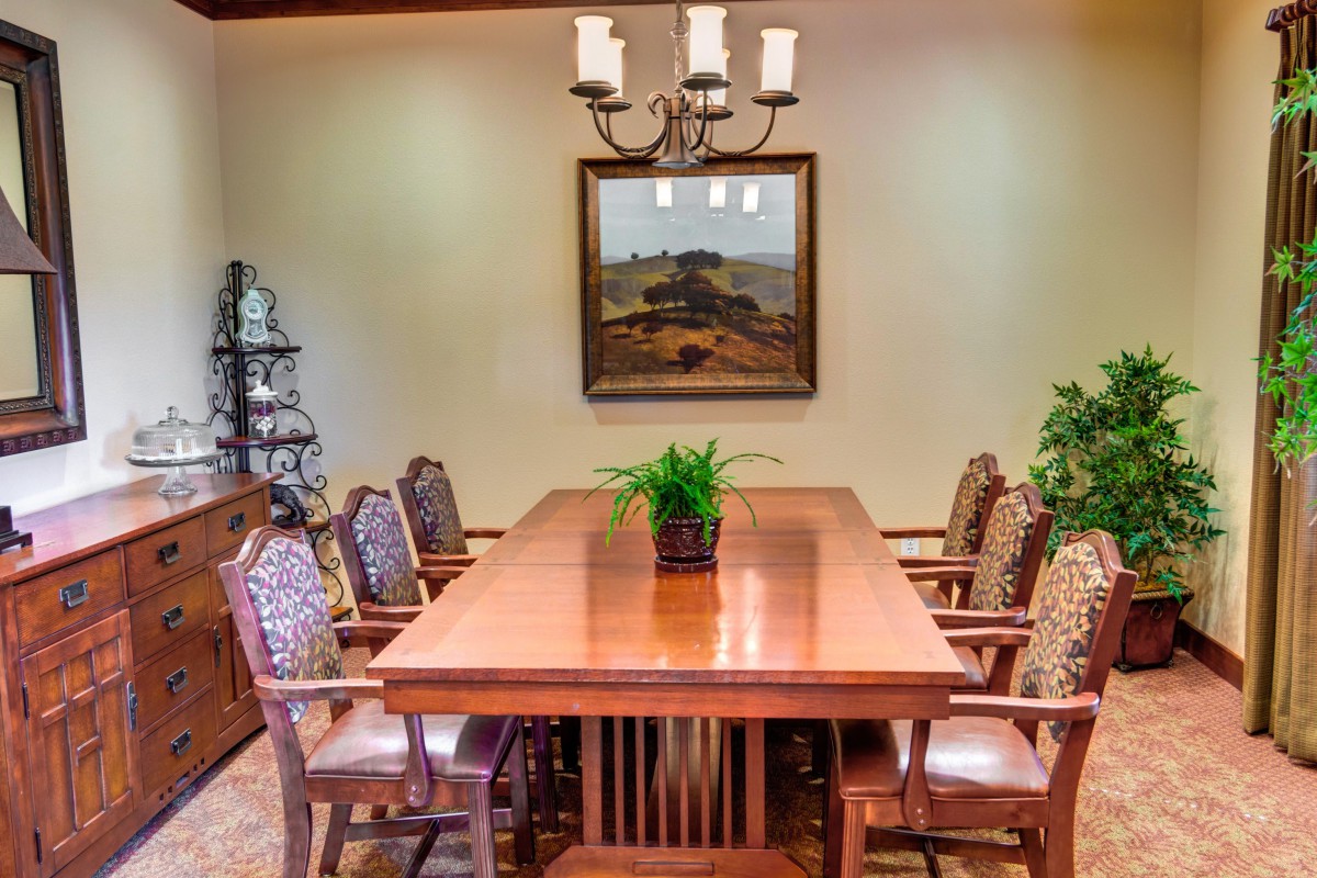 A well-furnished dining room with a wooden table, decorative chairs, and a chandelier.