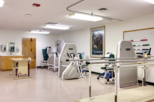 A well-equipped physical therapy room featuring various exercise machines and rehabilitation tools.