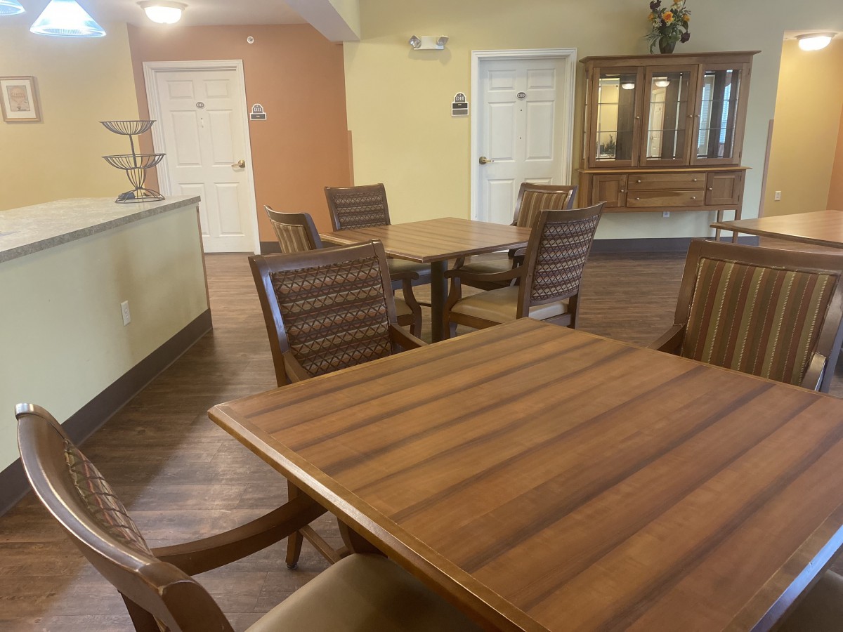 A communal dining area with wooden tables and chairs, showcasing a cozy and inviting atmosphere.