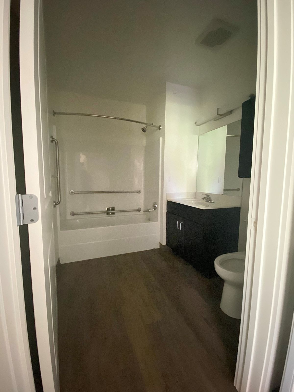 A modern bathroom with a combined shower and bathtub, sink, and toilet.